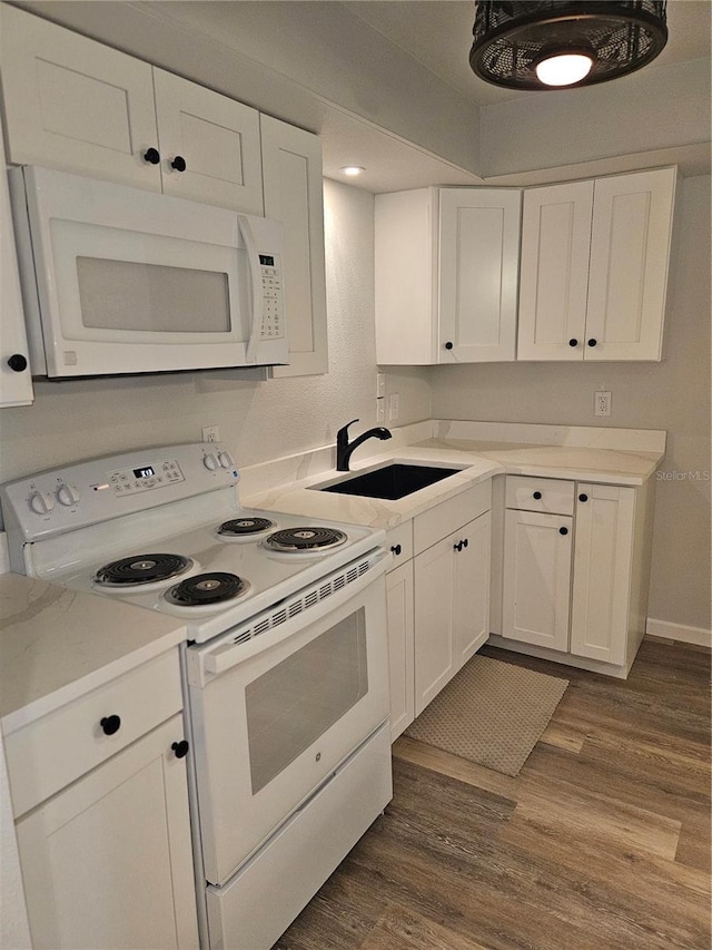 414 Danube Ave, Tampa, FL 33606 - kitchen featuring a sink, white appliances, dark wood finished floors, light countertops, and white cabinets