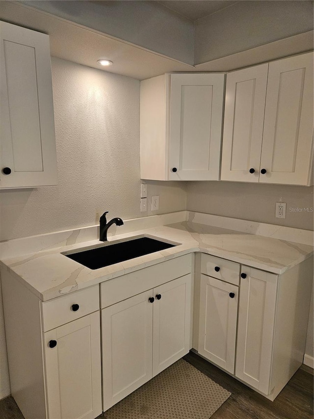 414 Danube Ave, Tampa, FL 33606 - kitchen with white cabinets, dark wood-type flooring, light stone counters, and a sink