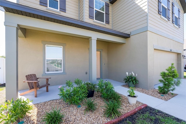 entrance to property with stucco siding and a garage