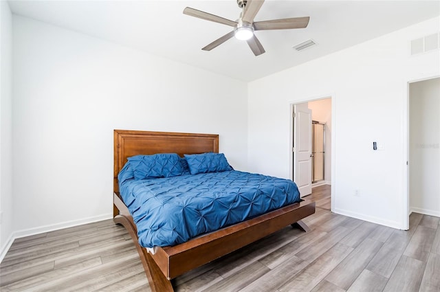 bedroom with baseboards, wood finished floors, visible vents, and ceiling fan