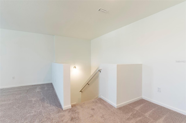 unfurnished room with light carpet, visible vents, and baseboards