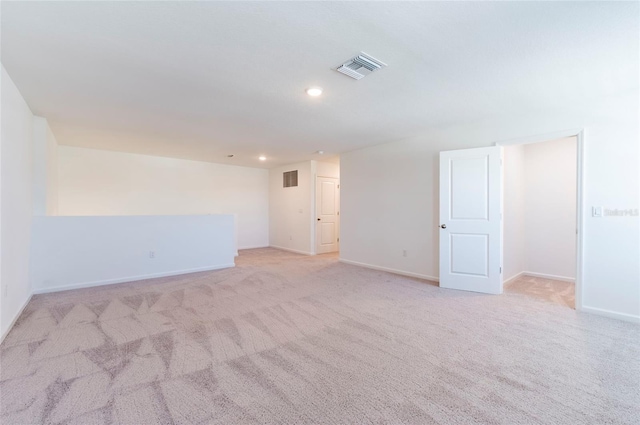 spare room with baseboards, visible vents, recessed lighting, and light colored carpet