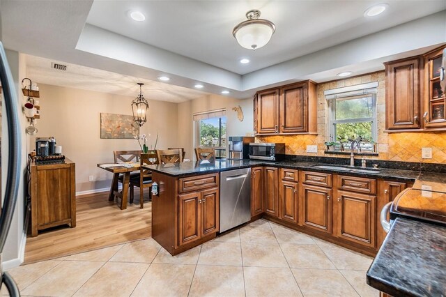 6821 Mary Lou Ln, Wesley Chapel, FL 33544 - kitchen with brown cabinets, stainless steel appliances, a sink, and a peninsula