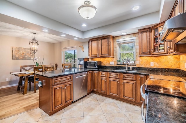 6821 Mary Lou Ln, Wesley Chapel, FL 33544 - kitchen featuring exhaust hood, brown cabinets, a sink, a peninsula, and stainless steel appliances