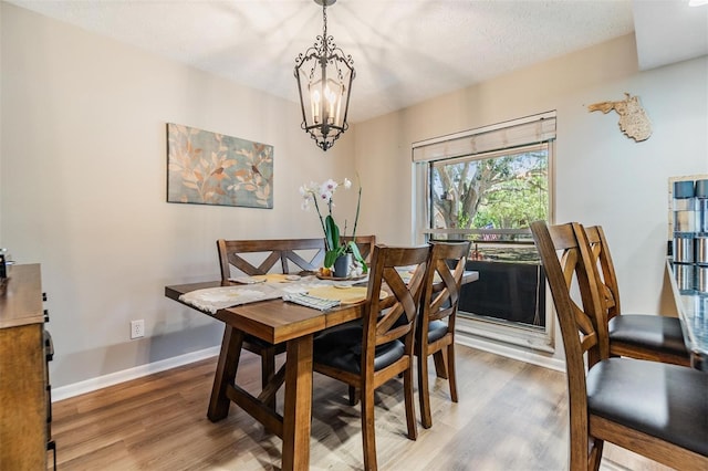6821 Mary Lou Ln, Wesley Chapel, FL 33544 - dining area with baseboards, wood finished floors, and a chandelier