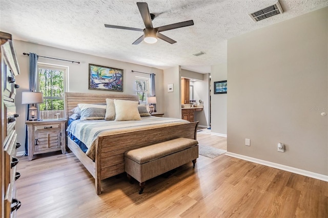 6821 Mary Lou Ln, Wesley Chapel, FL 33544 - bedroom with visible vents, a textured ceiling, light wood-style flooring, and baseboards