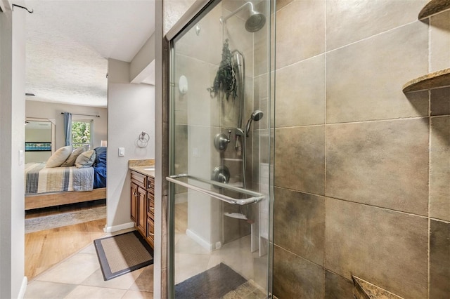 6821 Mary Lou Ln, Wesley Chapel, FL 33544 - full bathroom with vanity, baseboards, a textured ceiling, a shower stall, and ensuite bath