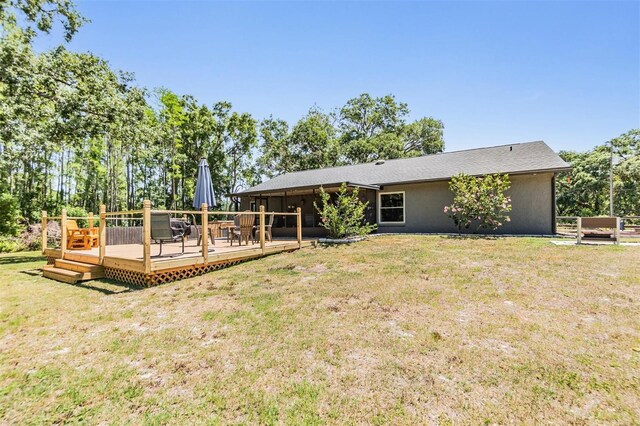 6821 Mary Lou Ln, Wesley Chapel, FL 33544 - back of property with a lawn, stucco siding, and a deck