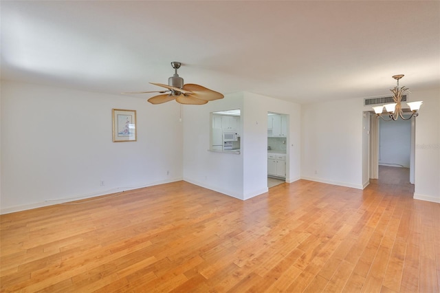 1802 Bedford Ter Unit 187, Sun City Center, FL 33573 - unfurnished room with a chandelier, light wood-style flooring, ceiling fan, and baseboards