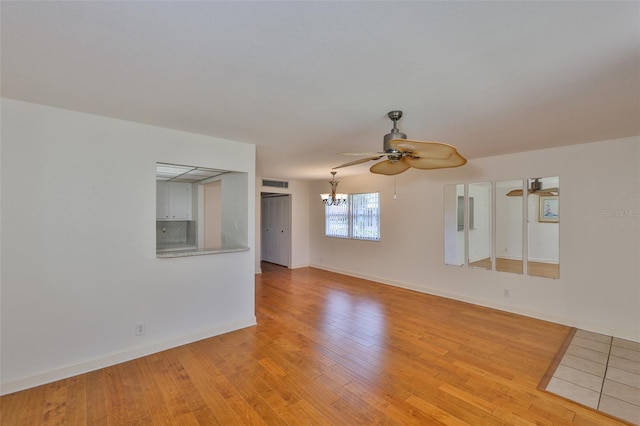 1802 Bedford Ter Unit 187, Sun City Center, FL 33573 - spare room with ceiling fan, light wood finished floors, a chandelier, and baseboards