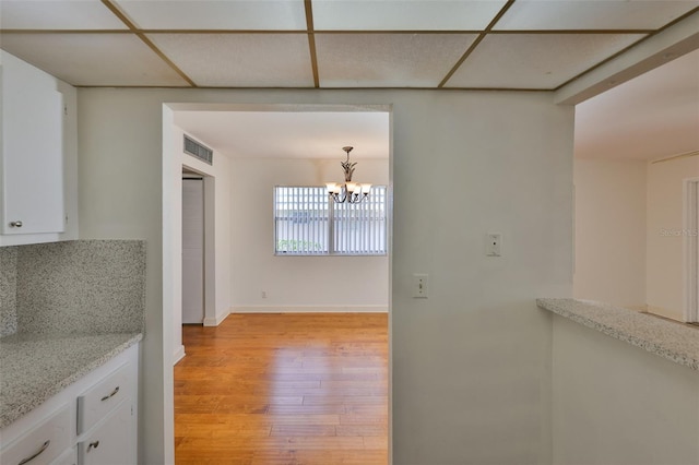 1802 Bedford Ter Unit 187, Sun City Center, FL 33573 - unfurnished dining area featuring light wood-style flooring, a chandelier, and baseboards