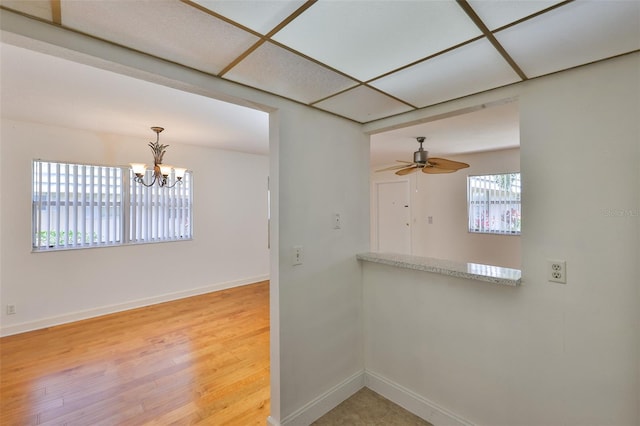 1802 Bedford Ter Unit 187, Sun City Center, FL 33573 - unfurnished room with baseboards, a ceiling fan, light wood-style flooring, and a chandelier