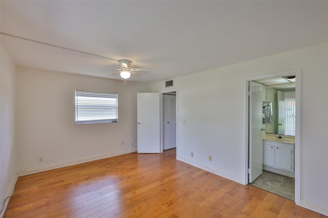 1802 Bedford Ter Unit 187, Sun City Center, FL 33573 - unfurnished bedroom with light wood-style flooring, connected bathroom, and baseboards