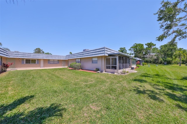 1802 Bedford Ter Unit 187, Sun City Center, FL 33573 - rear view of property with a yard, a sunroom, and stucco siding