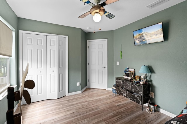11449 Crestlake Village Dr, Riverview, FL 33569 - bedroom featuring a ceiling fan, wood finished floors, a closet, baseboards, and visible vents