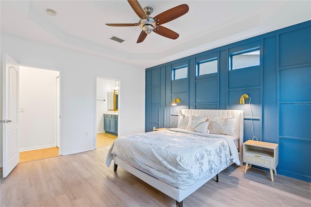 20121 Bending Creek Pl, Tampa, FL 33647 - bedroom with visible vents, light wood-style flooring, a raised ceiling, and baseboards