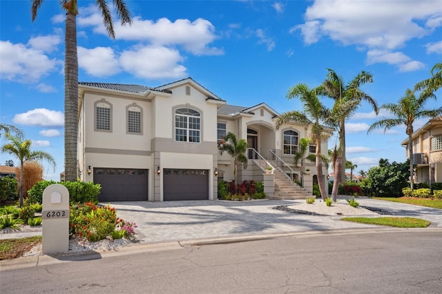 6202 Pasadena Point Blvd, Gulfport, FL 33707 - mediterranean / spanish house with stucco siding, an attached garage, stairway, and driveway