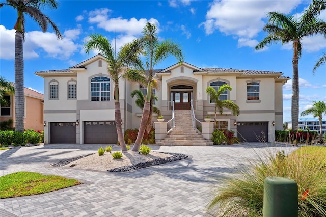 6202 Pasadena Point Blvd, Gulfport, FL 33707 - mediterranean / spanish-style house with an attached garage, french doors, stucco siding, stairs, and decorative driveway
