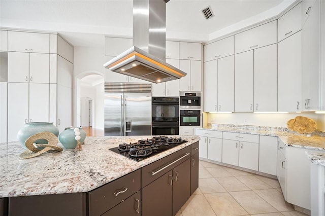 6202 Pasadena Point Blvd, Gulfport, FL 33707 - kitchen featuring black appliances, island exhaust hood, white cabinetry, light tile patterned floors, and light stone counters