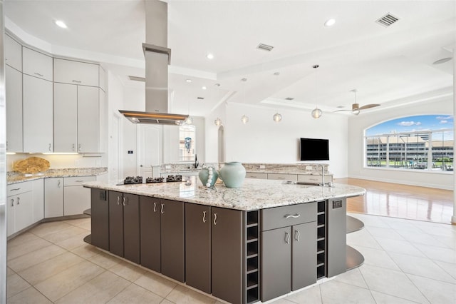 6202 Pasadena Point Blvd, Gulfport, FL 33707 - kitchen featuring open floor plan, a spacious island, light tile patterned floors, gas cooktop, and crown molding