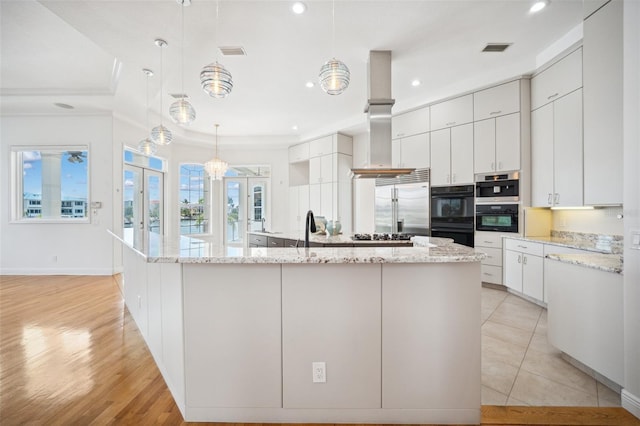 6202 Pasadena Point Blvd, Gulfport, FL 33707 - kitchen with stainless steel built in fridge, wall chimney exhaust hood, a spacious island, white cabinetry, and crown molding