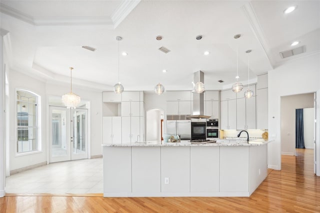 6202 Pasadena Point Blvd, Gulfport, FL 33707 - kitchen featuring crown molding, built in fridge, a peninsula, light stone counters, and light wood-style floors