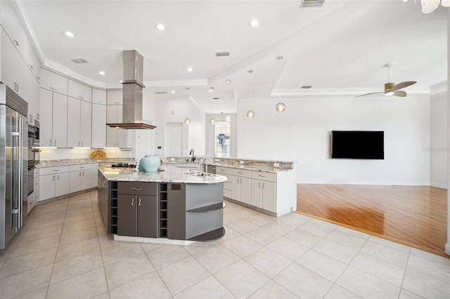 6202 Pasadena Point Blvd, Gulfport, FL 33707 - kitchen featuring wall chimney range hood, open shelves, a large island with sink, a ceiling fan, and light tile patterned floors