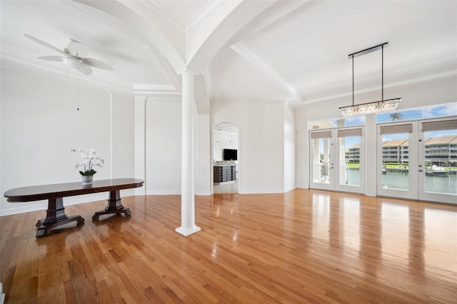 6202 Pasadena Point Blvd, Gulfport, FL 33707 - unfurnished living room featuring a ceiling fan, arched walkways, ornate columns, ornamental molding, and light wood-style floors