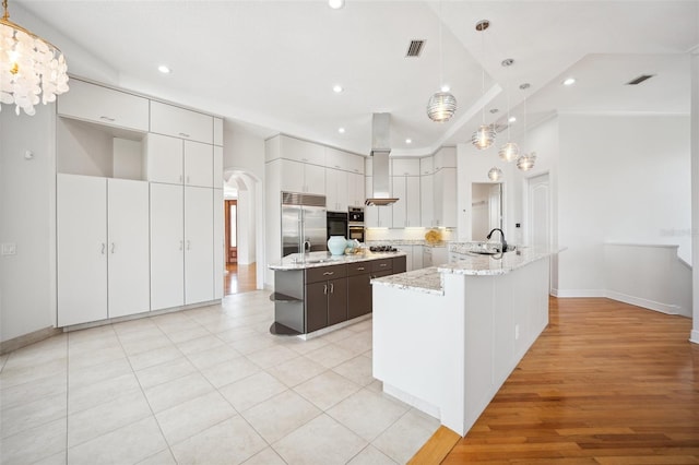 6202 Pasadena Point Blvd, Gulfport, FL 33707 - kitchen featuring a large island, stainless steel appliances, a sink, arched walkways, and recessed lighting