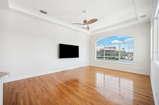 6202 Pasadena Point Blvd, Gulfport, FL 33707 - unfurnished living room with a tray ceiling, a ceiling fan, light wood-type flooring, and crown molding
