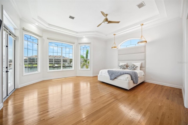 6202 Pasadena Point Blvd, Gulfport, FL 33707 - bedroom featuring a raised ceiling, multiple windows, light wood-style flooring, crown molding, and baseboards