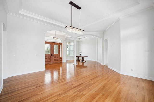 6202 Pasadena Point Blvd, Gulfport, FL 33707 - spare room featuring arched walkways, crown molding, light wood-type flooring, baseboards, and a tray ceiling
