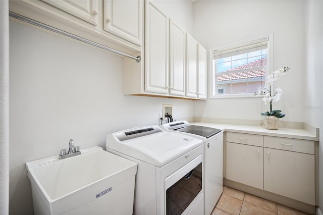 6202 Pasadena Point Blvd, Gulfport, FL 33707 - laundry room with cabinet space, washer and clothes dryer, and light tile patterned flooring
