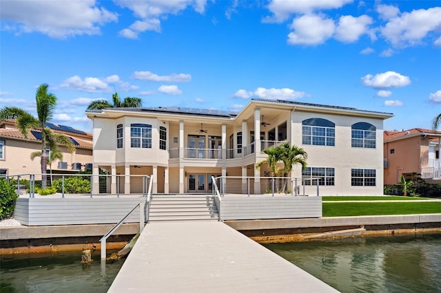 6202 Pasadena Point Blvd, Gulfport, FL 33707 - rear view of house featuring a balcony, ceiling fan, roof mounted solar panels, and a water view