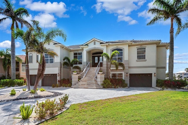 6202 Pasadena Point Blvd, Gulfport, FL 33707 - mediterranean / spanish home featuring a garage, stucco siding, a front yard, and driveway