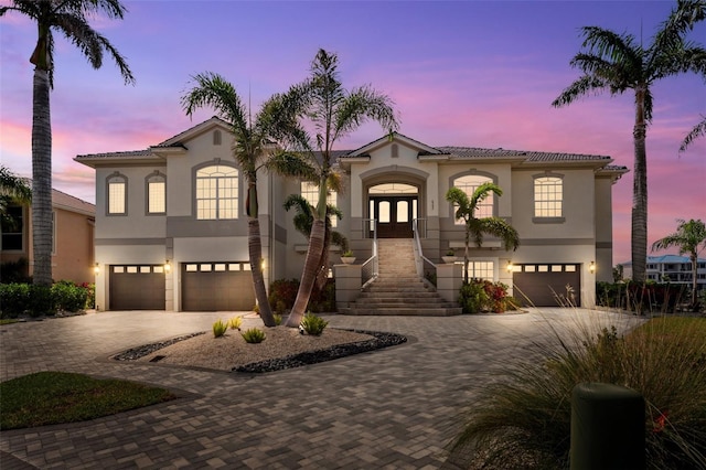 6202 Pasadena Point Blvd, Gulfport, FL 33707 - mediterranean / spanish house with french doors, an attached garage, decorative driveway, and stucco siding