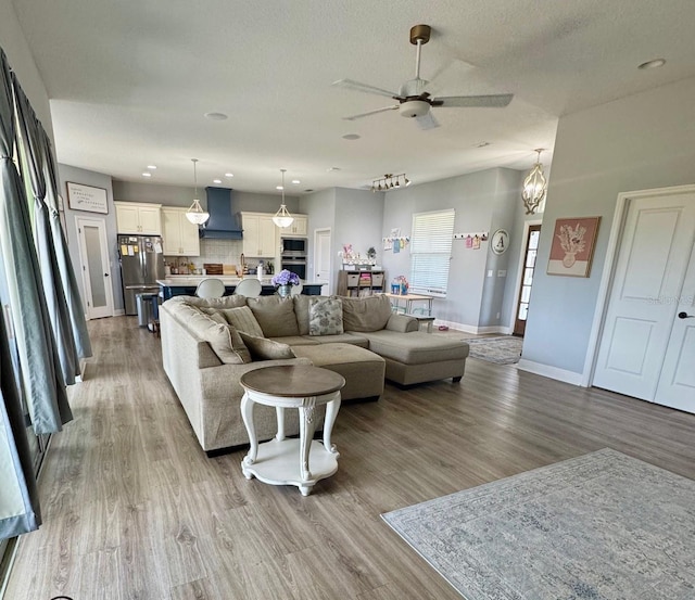 living area featuring baseboards, a ceiling fan, recessed lighting, and wood finished floors