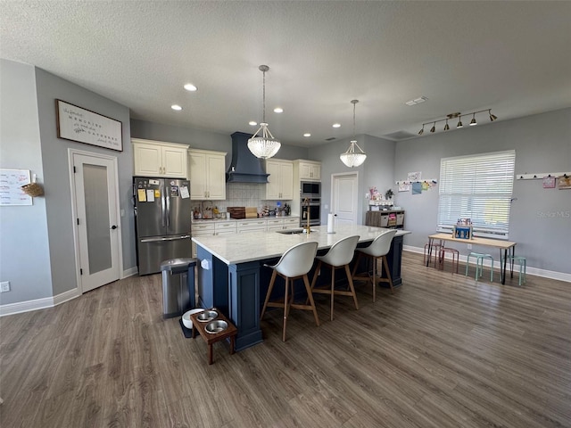 kitchen featuring a spacious island, appliances with stainless steel finishes, dark wood-style floors, and custom range hood
