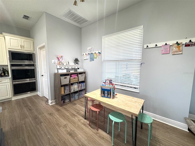 dining room with baseboards, visible vents, and wood finished floors