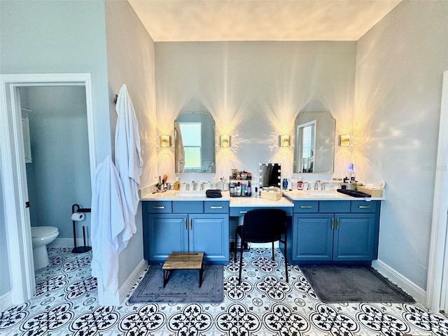 full bathroom with double vanity, a sink, tile patterned floors, and toilet