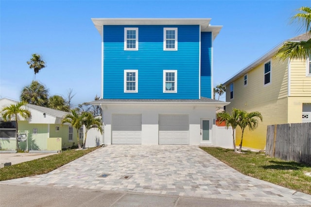 13117 4th St E, Madeira Beach, FL 33708 - coastal inspired home with fence, decorative driveway, and an attached garage