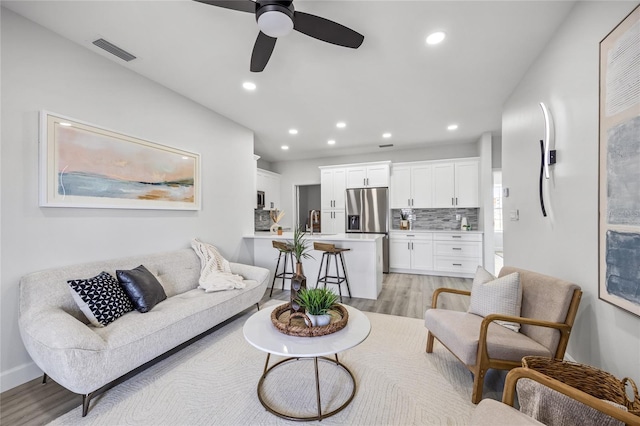 13117 4th St E, Madeira Beach, FL 33708 - living room featuring light wood-style flooring, ceiling fan, and recessed lighting