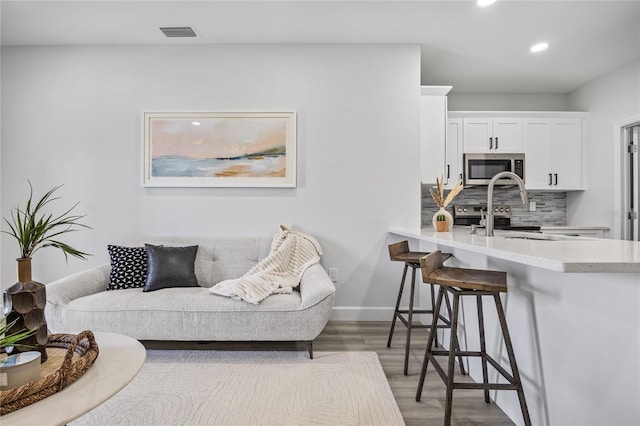 13117 4th St E, Madeira Beach, FL 33708 - living area with recessed lighting, light wood-style floors, and baseboards