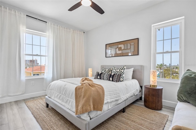 13117 4th St E, Madeira Beach, FL 33708 - bedroom featuring multiple windows, wood finished floors, baseboards, and ceiling fan