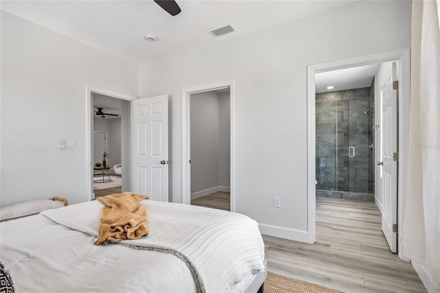 13117 4th St E, Madeira Beach, FL 33708 - bedroom with baseboards, light wood-type flooring, ensuite bath, and a ceiling fan