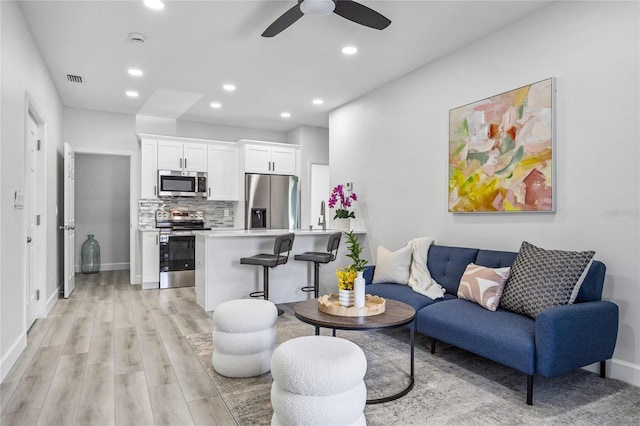 13117 4th St E, Madeira Beach, FL 33708 - living room featuring ceiling fan, recessed lighting, light wood-type flooring, and baseboards
