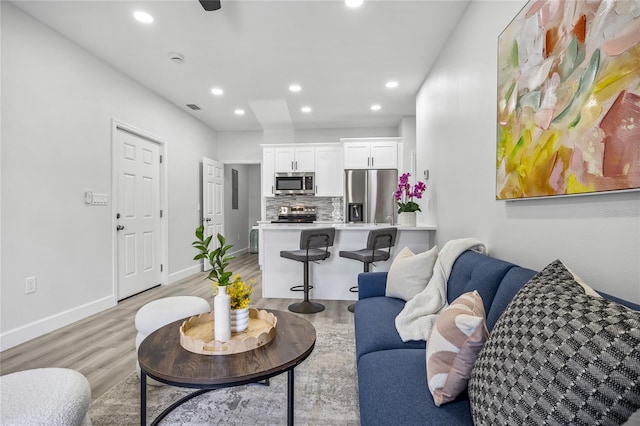 13117 4th St E, Madeira Beach, FL 33708 - living room with light wood-type flooring, recessed lighting, and baseboards
