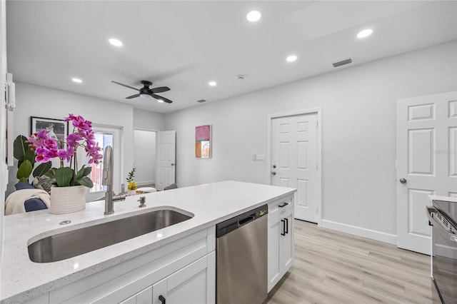 13117 4th St E, Madeira Beach, FL 33708 - kitchen with stainless steel dishwasher, a sink, white cabinets, a ceiling fan, and light wood-type flooring