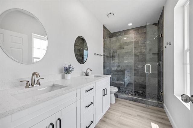 13117 4th St E, Madeira Beach, FL 33708 - bathroom with toilet, a shower stall, double vanity, wood finished floors, and recessed lighting