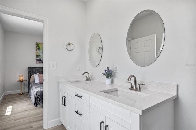 13117 4th St E, Madeira Beach, FL 33708 - full bathroom with wood finished floors, baseboards, and double vanity